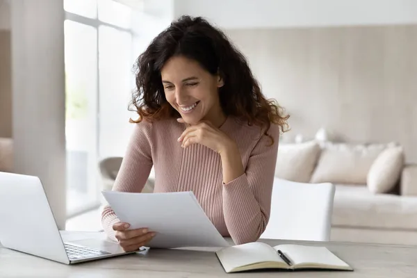 Glad affärskvinna läser goda nyheter i brev, sitter vid skrivbordet — Stockfoto