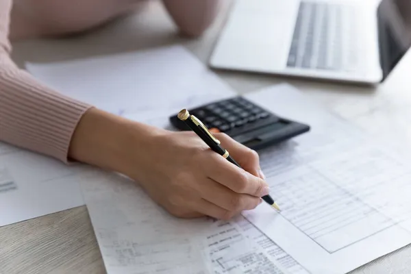 Close up woman filling financial documents, calculating bills or taxes — Stock Photo, Image