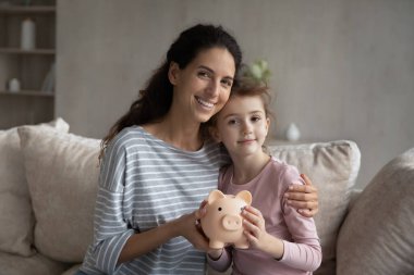 Kafasından vurulmuş anne ve küçük kızı domuz kumbarası tutuyor.