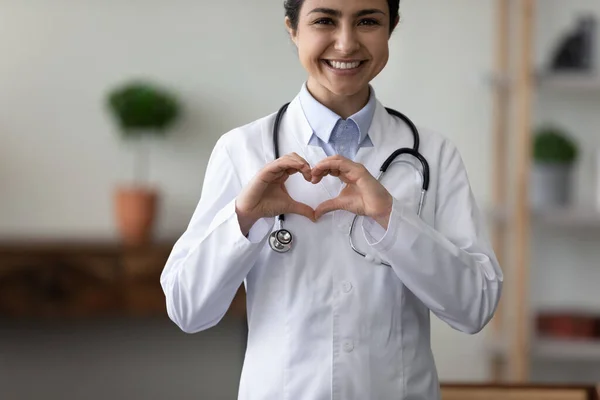 Retrato sonriente mujer india médico en uniforme mostrando el gesto del corazón — Foto de Stock