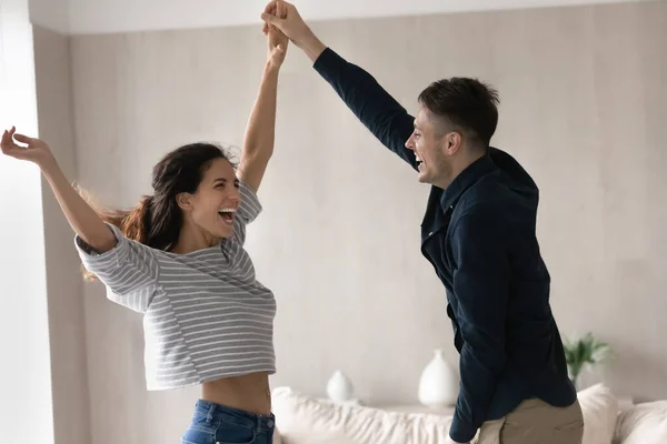Couple joyeux tenant la main dansant à la maison — Photo