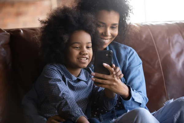 Feliz vinculación afro-americana familia usando el teléfono celular. — Foto de Stock