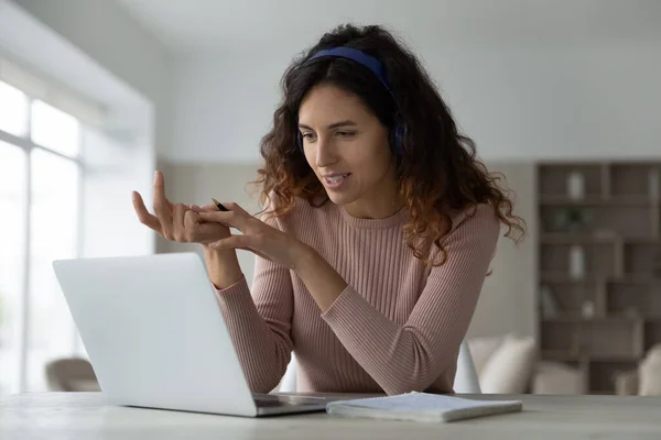 Woman in headphones chatting online by video call, using laptop — Stock Photo, Image