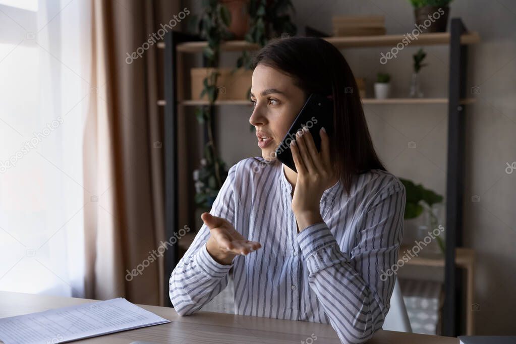 Focused young woman involved in mobile phone call talk.
