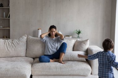 İtaatsiz çocuk oturma odasında koşuyor ve annemi rahatsız ediyor.