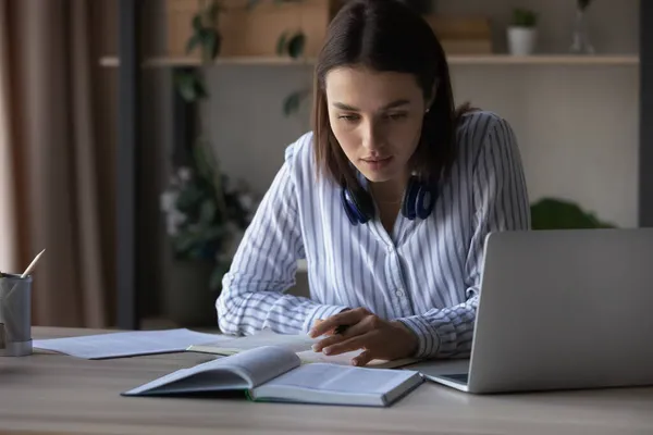 Koncentrerad ung 20-tals kvinnlig student läser lärobok. — Stockfoto