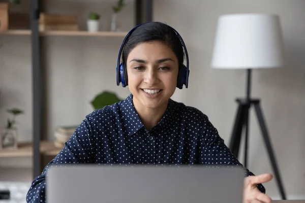 Smiling young Indian businesswoman in headphones holding video call. — Stock Photo, Image