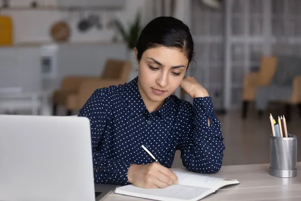 Focused millennial Indian woman handwriting notes in copybook. — Stock Photo, Image