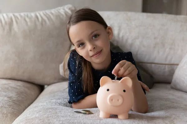 Niedliches sparsames kleines Mädchen legte Münze in Sparschwein — Stockfoto
