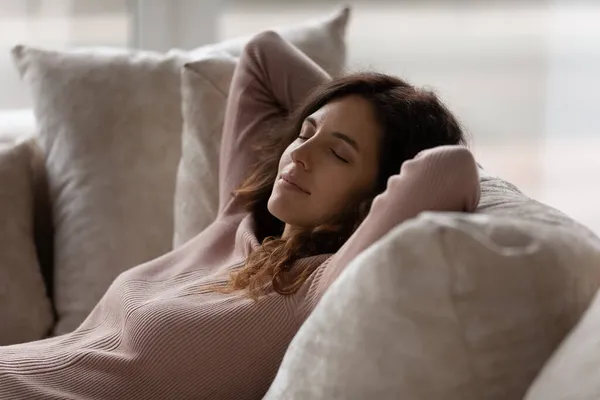 Närbild fridfull kvinna med slutna ögon vilar på soffan — Stockfoto