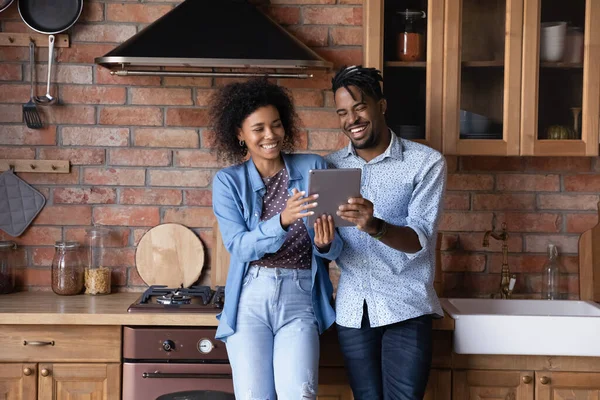 Gelukkig jong Afro-Amerikaans gezin paar met behulp van digitale tablet. — Stockfoto