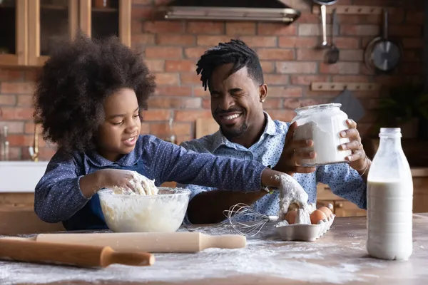 Gioiosa piccola famiglia afroamericana che cucina insieme in cucina. — Foto Stock