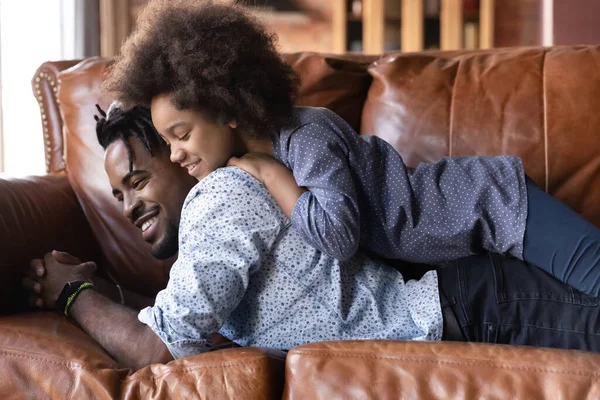 Glimlachende jonge Afro-Amerikaanse vader vasthouden aan terug schattige gelukkige dochter. — Stockfoto