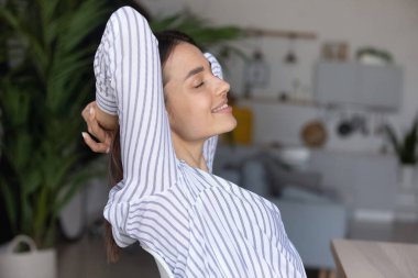 Gülümseyen genç ve güzel iş kadını iş yerinde dinleniyor..