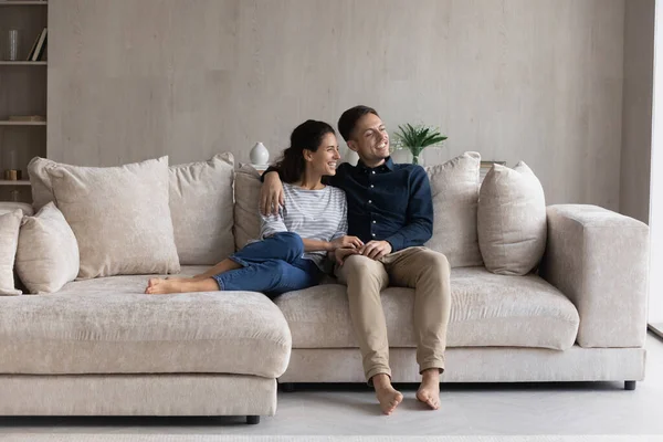 Peaceful couple relaxing on comfortable couch looking out window — Stock Photo, Image