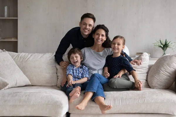 Feliz hermosa pareja con niños pequeños posando para la foto —  Fotos de Stock