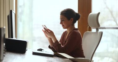 Genç Hintli kadın iş yerinde mobil uygulamada web 'e göz atıyor