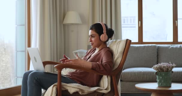 Relaxált indiai nő fülhallgatóban beszél videóval a PC-n — Stock videók