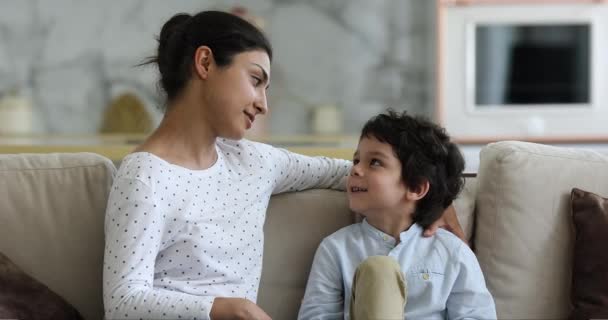Vänlig indisk mor sitter på soffan prata med lille son — Stockvideo