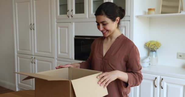 Happy Indian housewife unpack dishes at kitchen in moving day — Stock Video