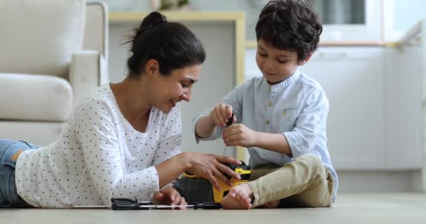 Indische alleinerziehende Mutter hilft kleinem Sohn, kaputtes Auto zu reparieren — Stockvideo