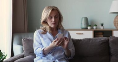 Yaşlı bayan uygulamada akıllı telefon ağı kullanarak evde rahatlar.