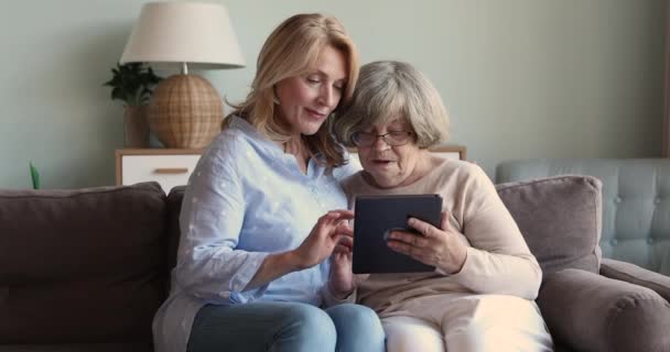 Ältere Tochter lehrt erwachsene Mutter, Touchpad zu benutzen — Stockvideo