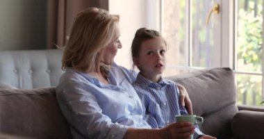 Küçük kız kanepeye oturup yaşlı büyükannenle sorunlarını paylaşıyor.