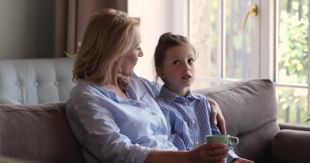 Niña sentarse en el sofá compartir problemas con la abuela de edad — Vídeo de stock