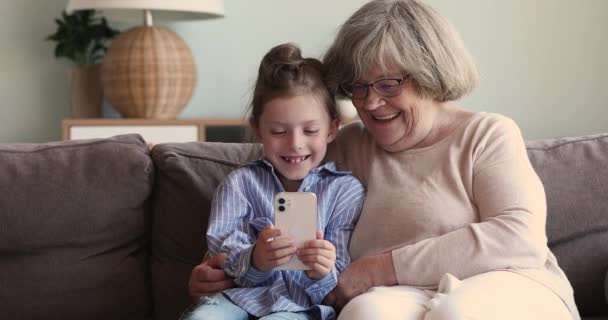 Malá holka starší dospělá babička dělat legrační selfie na buňce — Stock video