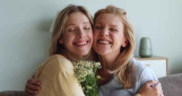 Cariñosa mamá adulto hija abrazo mirada en cámara celebrar flores — Vídeos de Stock