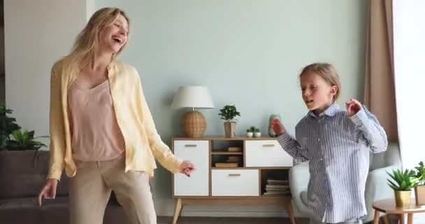Молодая няня танцует дома с маленькой девочкой — стоковое видео