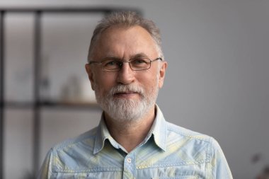 Mutlu son sınıf gri saçlı, sakallı 60 'lı yaşlarda bir adam.