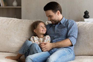 Sevgi dolu genç baba küçük kızıyla konuşuyor..