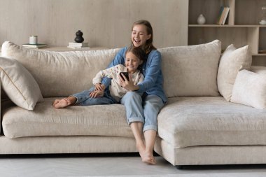 Akıllı telefon kullanan neşeli, samimi iki kadın nesil ailesi..