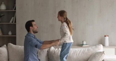Sevgi dolu baba, küçük kızının kanepede zıplamasına izin verir.