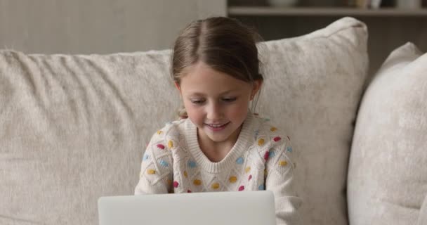 Συγκεντρωμένο κοριτσάκι που ασχολείται με την αναπαραγωγή βιντεοπαιχνιδιών σε φορητό υπολογιστή — Αρχείο Βίντεο