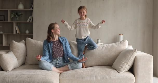 Gadis kecil yang lucu bersenang-senang meniru meditasi ibu yogi — Stok Video