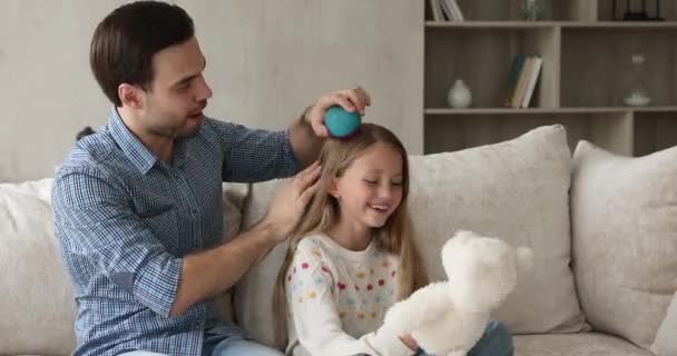 Opieka samotny tata szczotka włosy młodszej córki w wieku szkolnym — Wideo stockowe