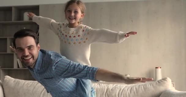 Overgelukkig jonge vader dragen opgewonden kleine dochter op de rug — Stockvideo