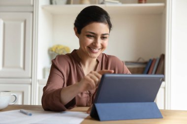 Dijital bilgisayar tableti kullanan mutlu Hintli kadın.