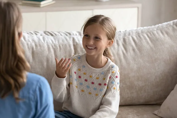 Sonriente linda niña practicando la articulación con terapeuta profesional. — Foto de Stock