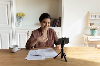 Gülümseyen genç Hintli kadın eğitici video kaydediyor..