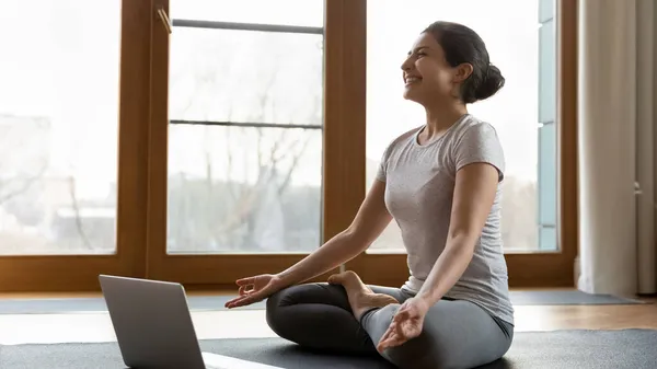 Happy sincere young indian woman enjoying online yoga training. — Stock Photo, Image