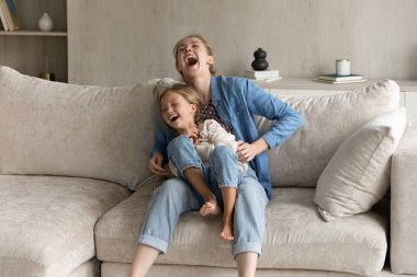 30 'lu yaşlardaki neşeli anne küçük kızıyla oynuyor..