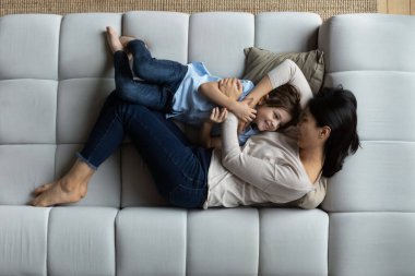 Aile kanepede uzanıyor, sarılıyor, hafta sonunun ve zamanın tadını çıkarıyor.