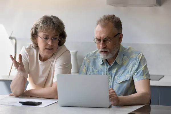 Сосредоточенные пожилая пара, зрелый муж и жена оплачивают счета — стоковое фото