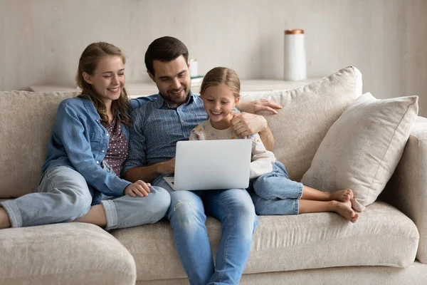 Jovens pais caucasianos felizes usando computador com filha pequena. — Fotografia de Stock