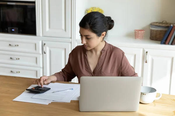 Concentrated millennial indian woman calculating expenditures at home. — Stock Photo, Image