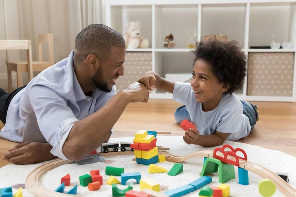 Pai orgulhoso e filho feliz batendo punhos sobre blocos de brinquedo — Fotografia de Stock
